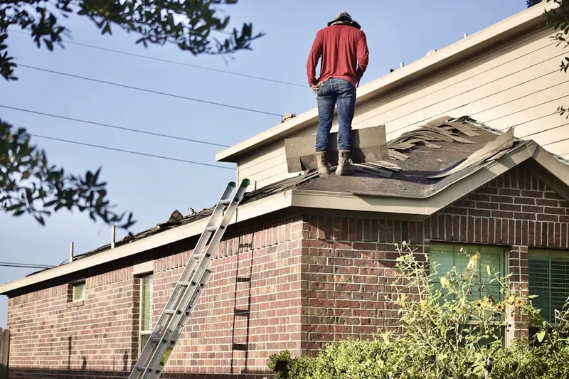 Professional roofer working on a residential roof in Kolbes Corner